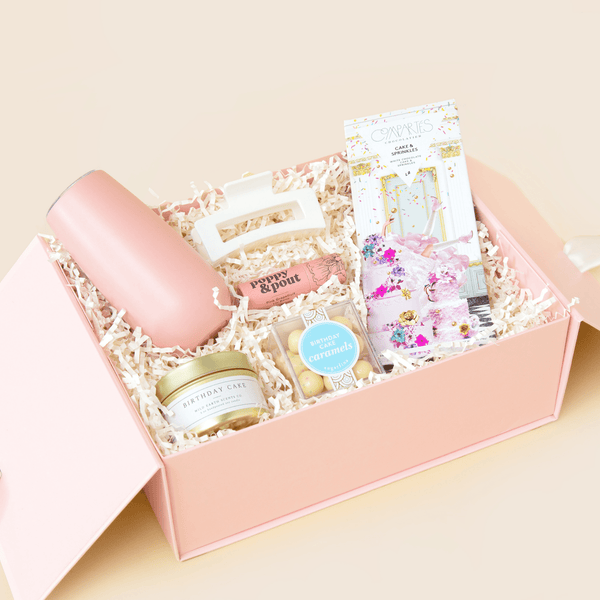 Cake and Sprinkles birthday gift box with cake caramels, lip balm, and champagne flute in a pink Unboxme gift box