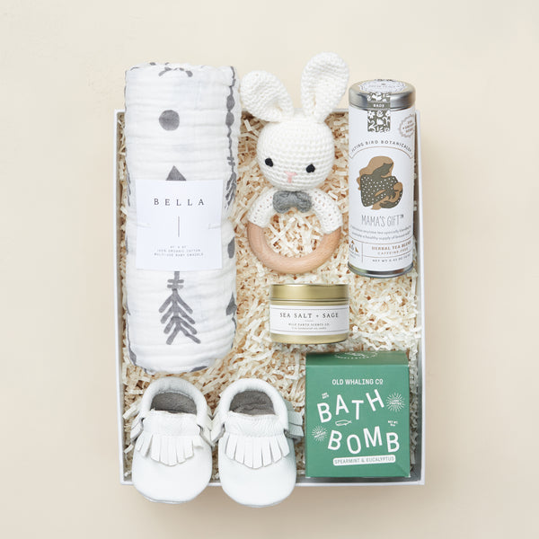 New baby gift box with swaddle, booties, bath bombs, and herbal tea in a blue Unboxme gift box