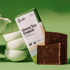 Raaka Green Tea Crunch chocolate bar with packaging on a green background